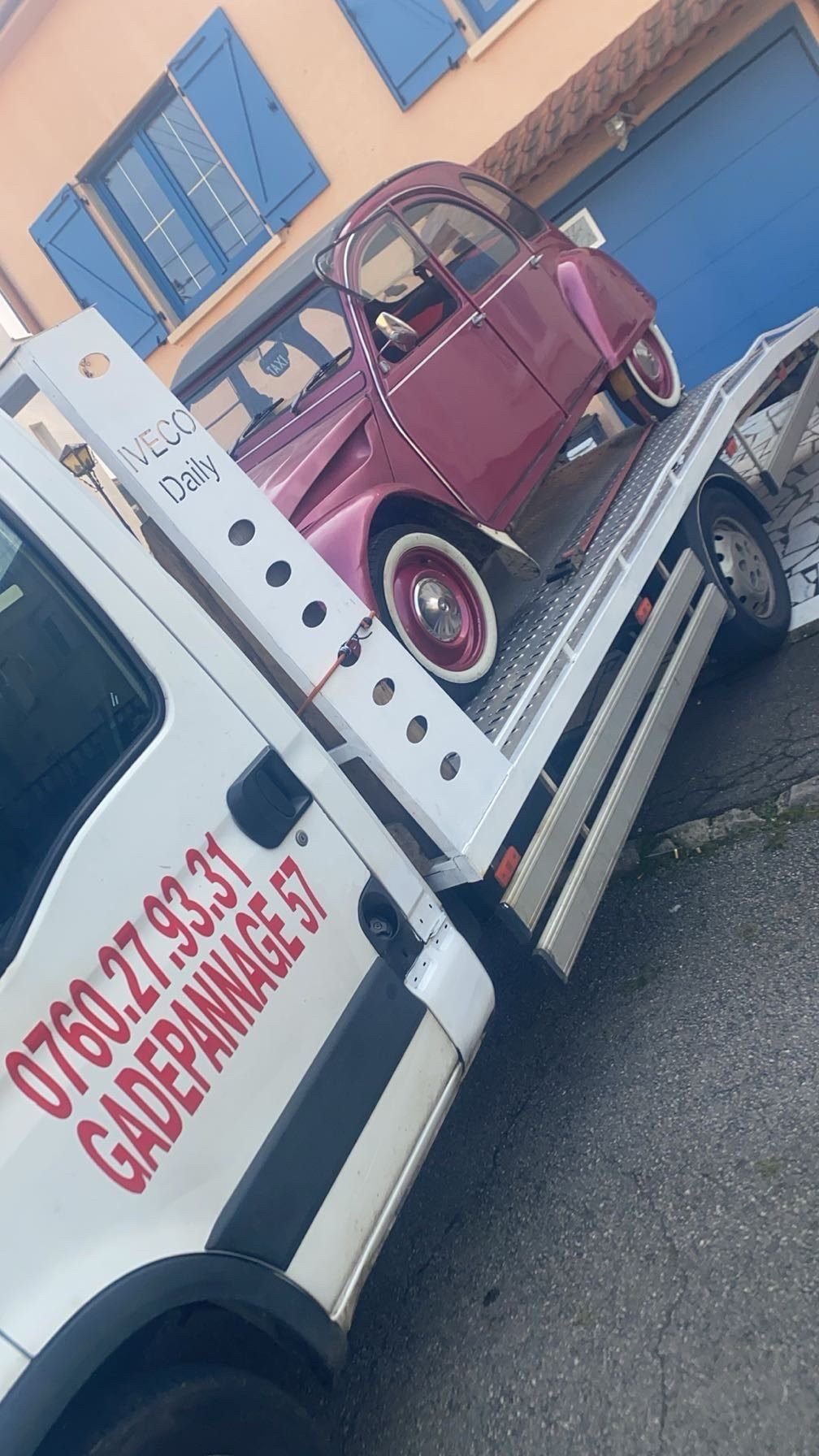 Citroën 2CV rose arrimée sur le plateau d’une dépanneuse GA Dépannage