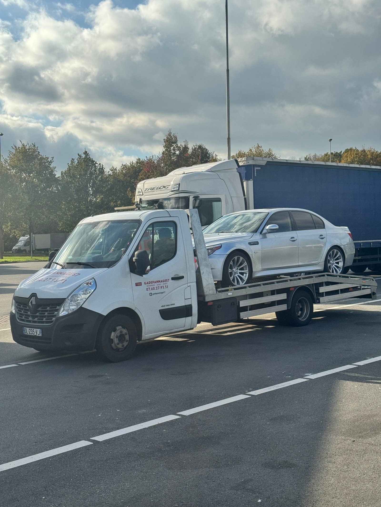 Camion plateau GA Dépannage transportant une berline argentée