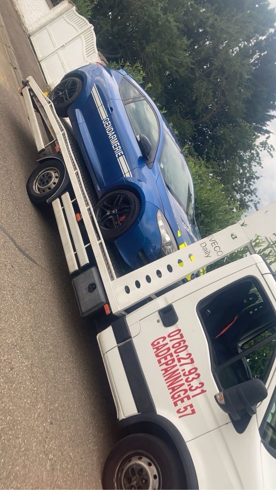 Voiture de gendarmerie bleue chargée sur une dépanneuse plateau GA Dépannage
