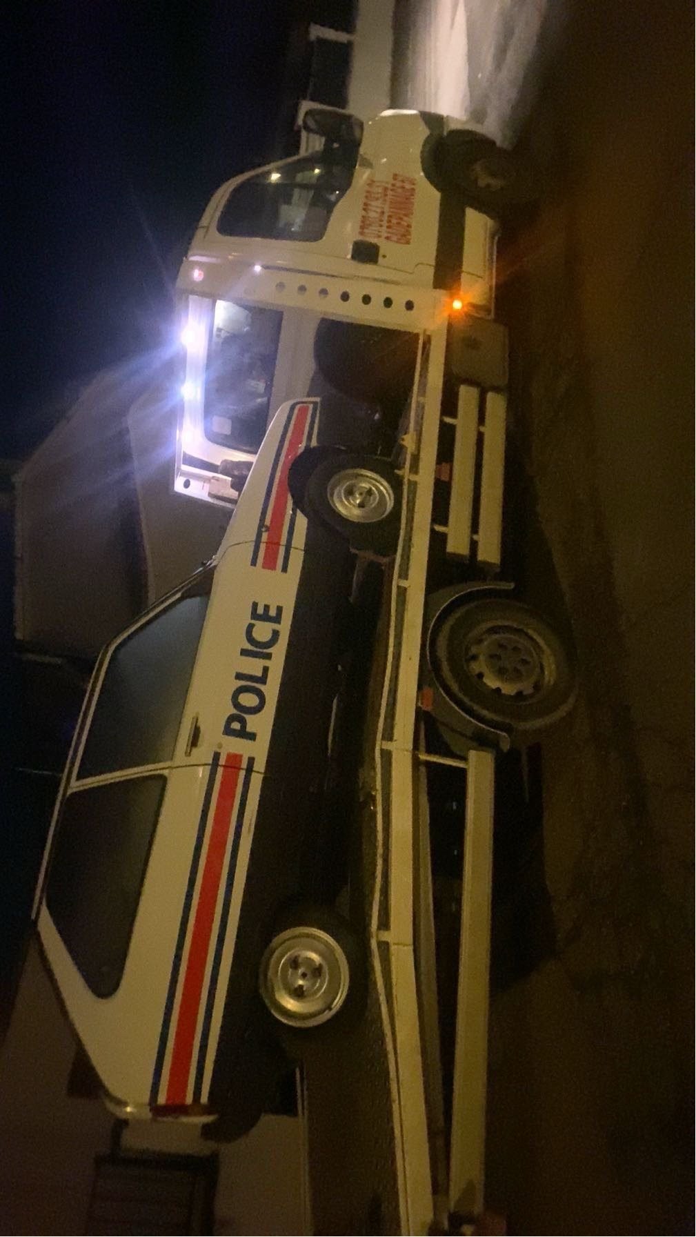 Véhicule de police transporté de nuit sur une dépanneuse plateau